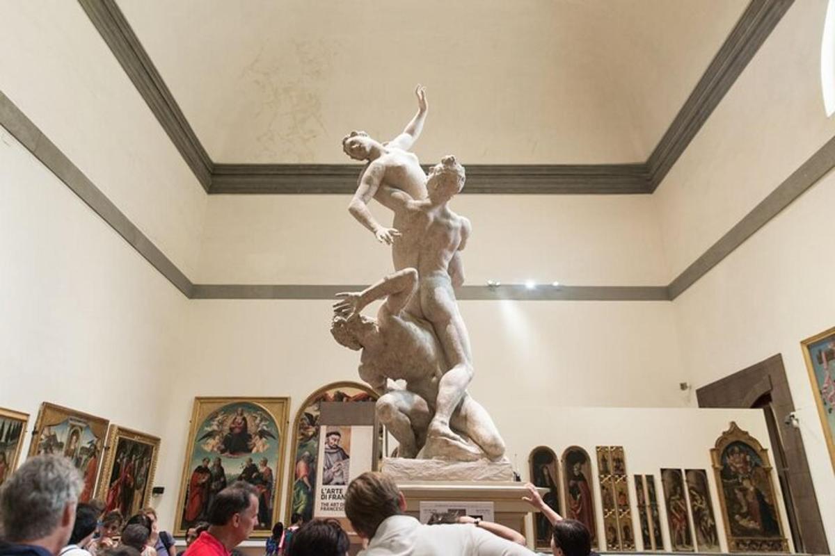 Una multitud de personas mirando una estatua en un museo.