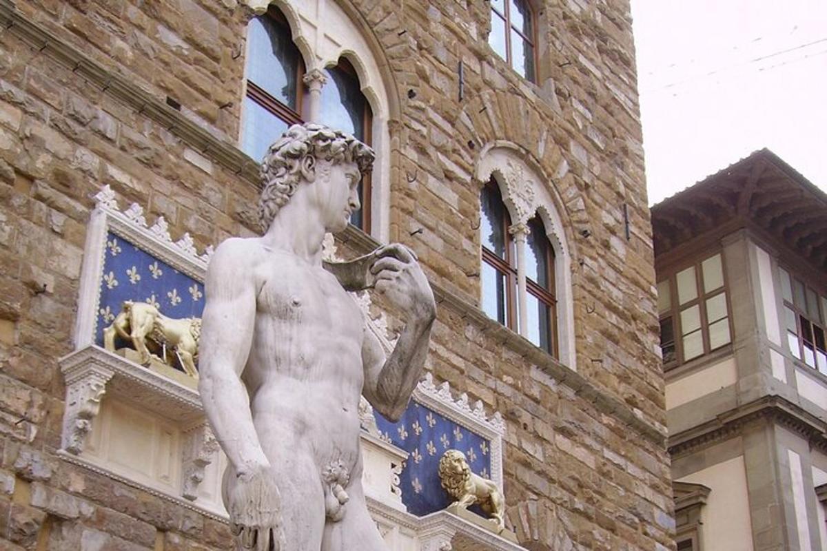 Una estatua de un hombre fumando una pipa frente a un edificio.