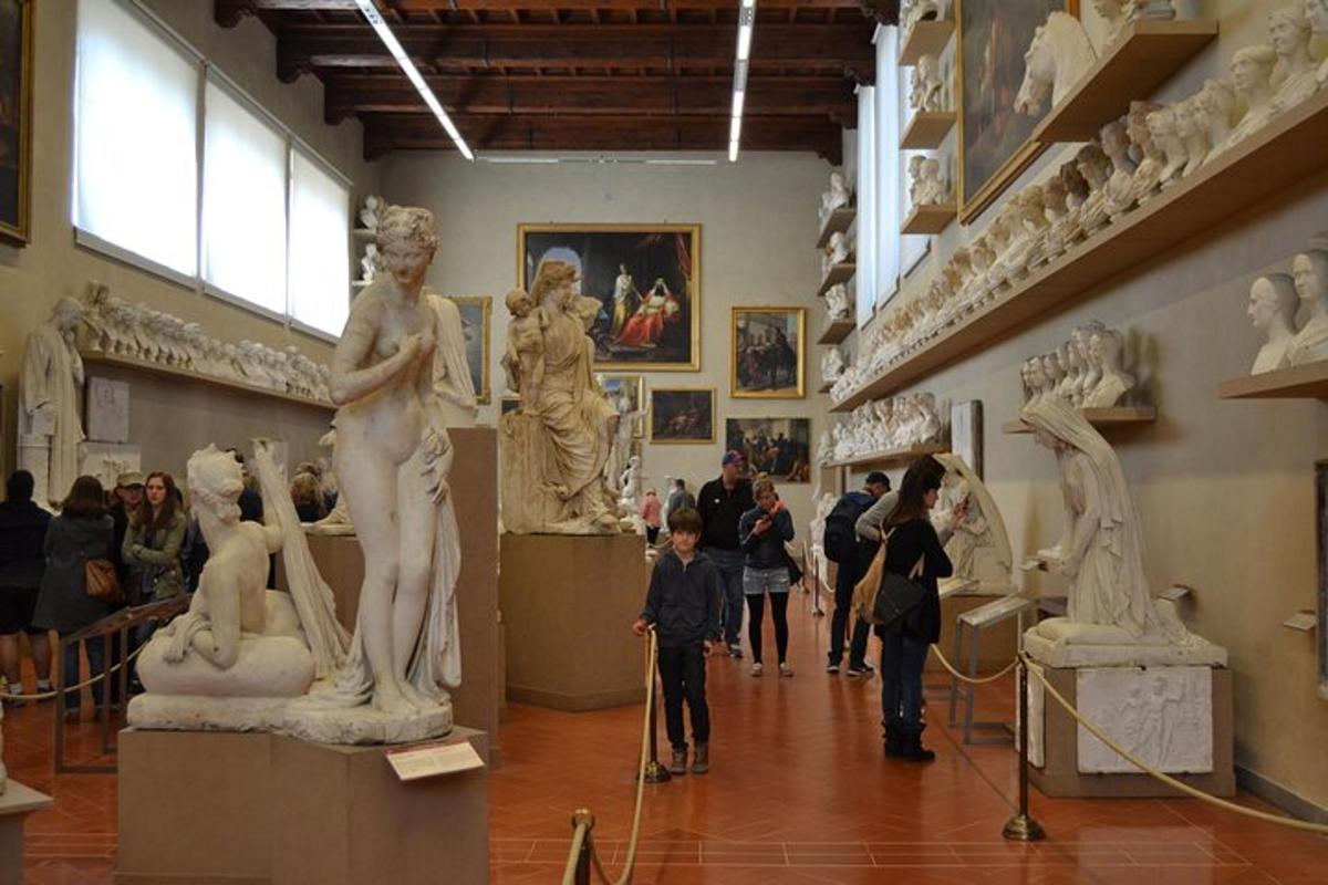 Un grupo de personas mirando estatuas en un museo.