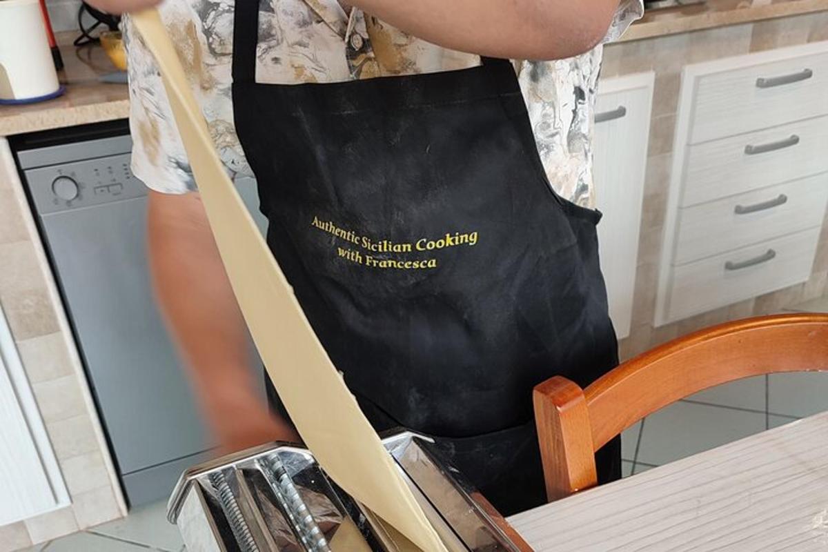 Maður í eldhúsi með svarta svuntu
