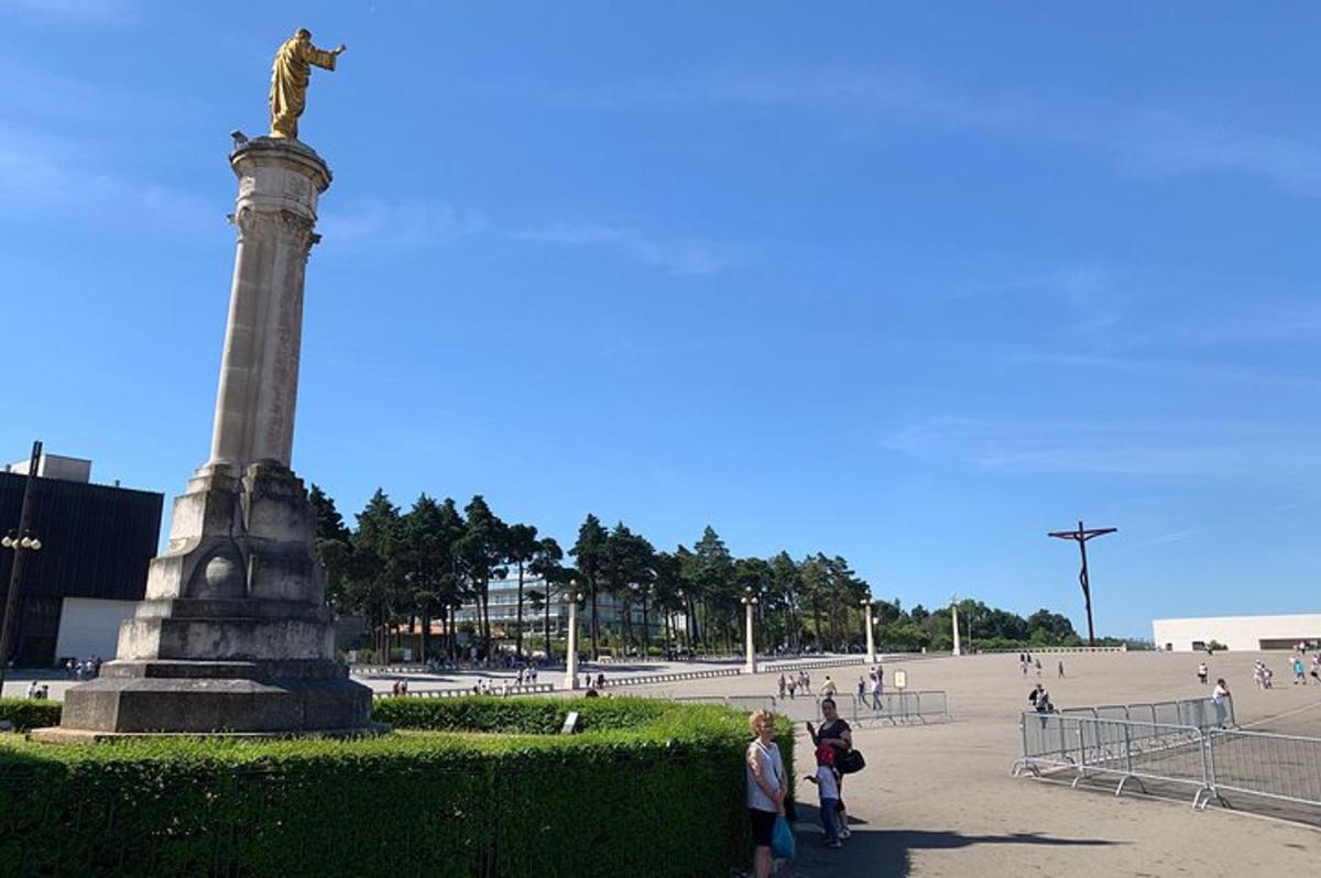 a statue in a park with people standing around it
