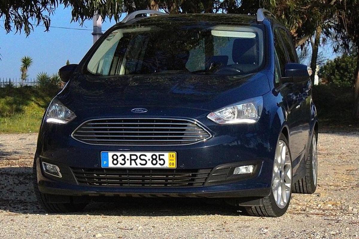 modré auto zaparkované na štěrkovém parkovišti