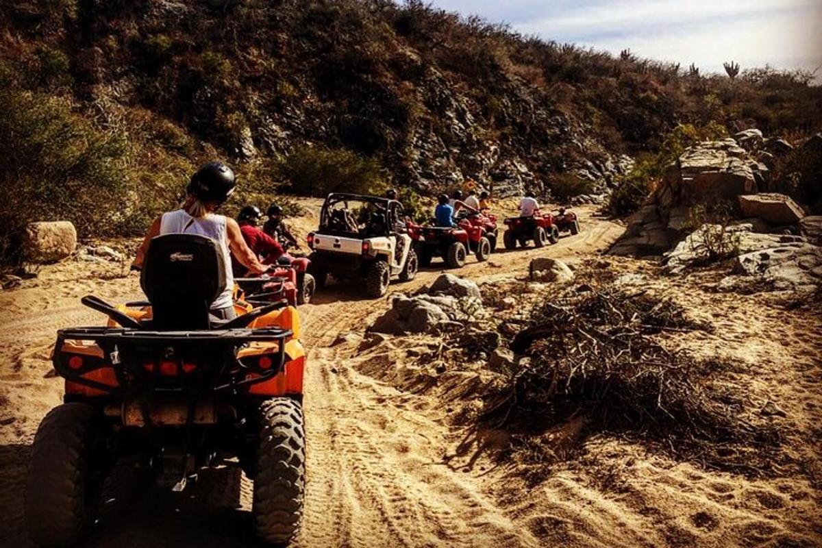 Un grupo de personas en vehículos todo terreno en un camino de tierra