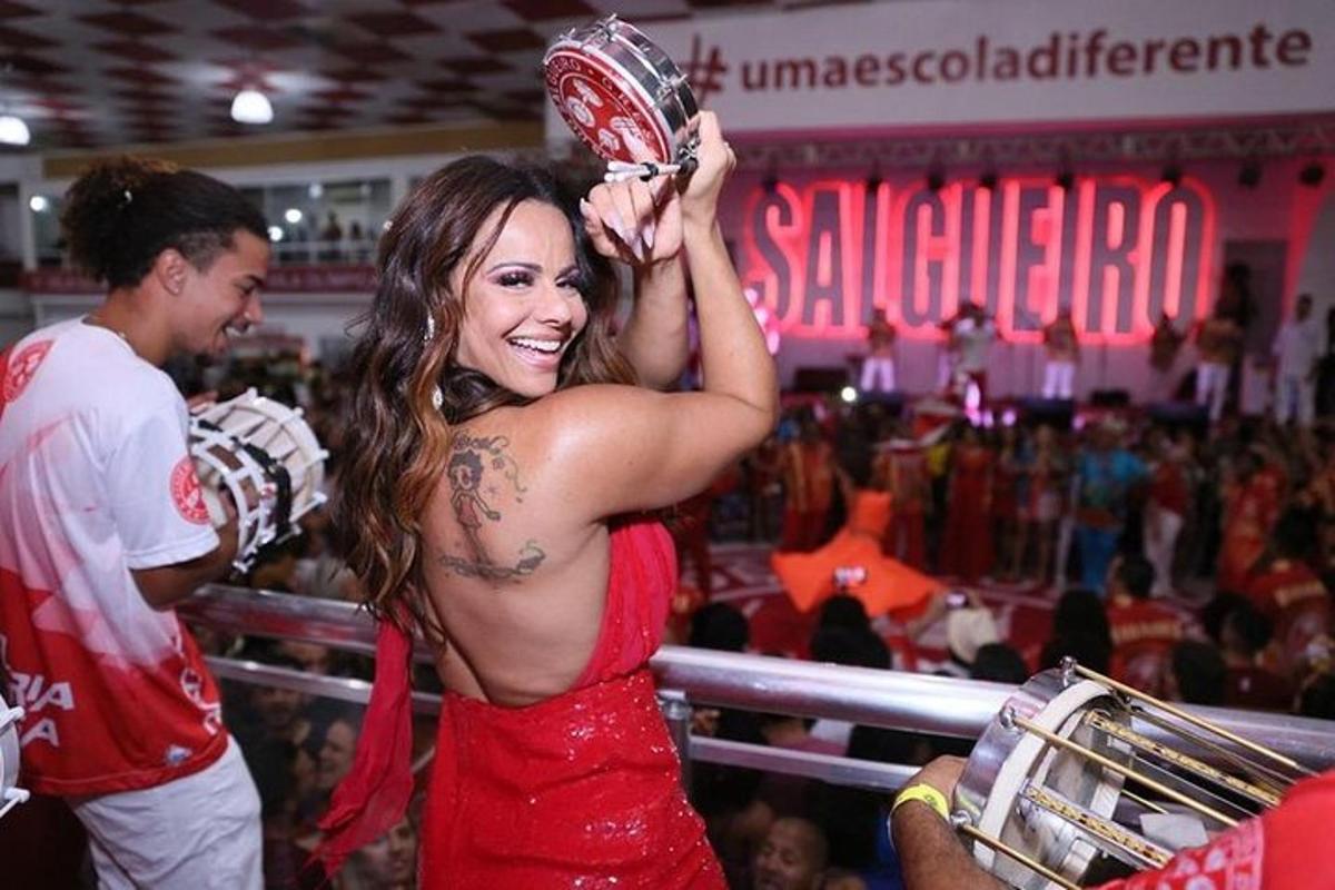 Una mujer sosteniendo un trofeo frente a una multitud.