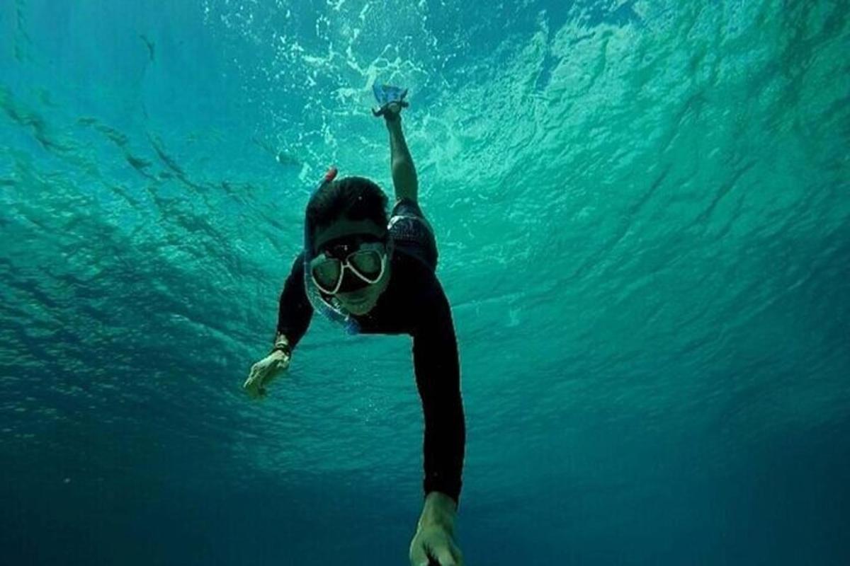 a person in a wetsuit and goggles swimming in the water