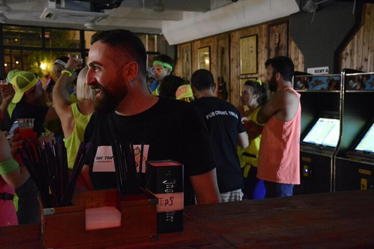 seorang lelaki berdiri di sebuah bar dalam kerumunan orang ramai