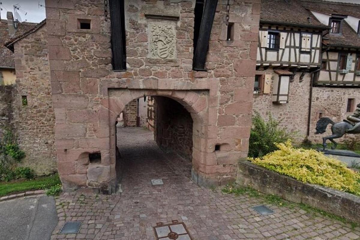 a brick building with an archway in front of a building