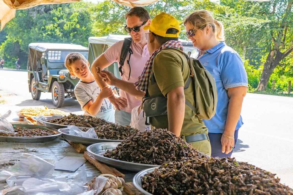 eine Gruppe von Menschen steht um einen Tisch voller Insekten
