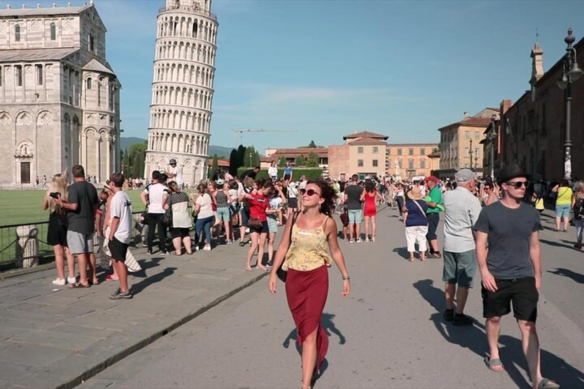 Una mujer caminando por una calle frente a la torre inclinada
