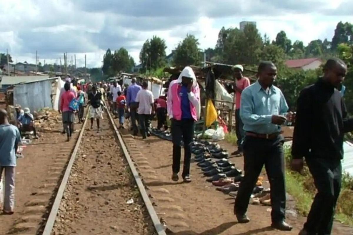 una folla di persone che camminano lungo i binari del treno