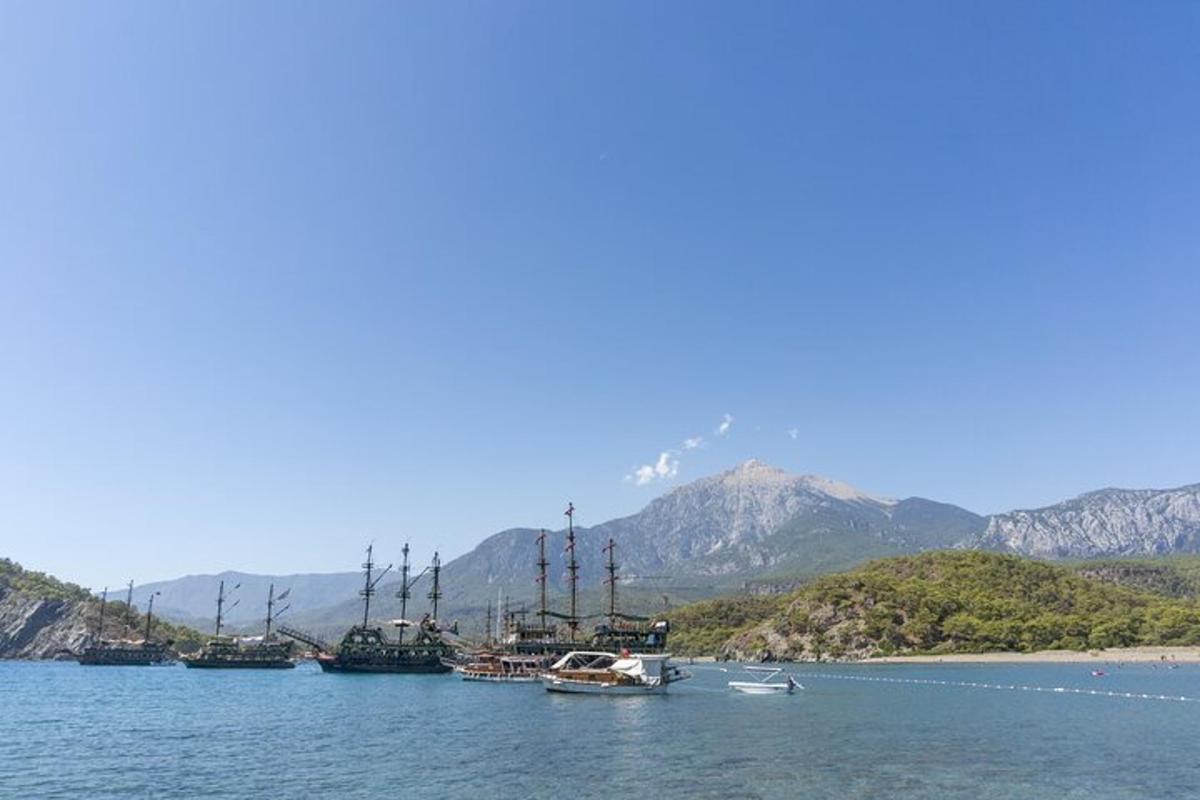 Μια ομάδα σκαφών στο νερό με βουνά στο φόντο