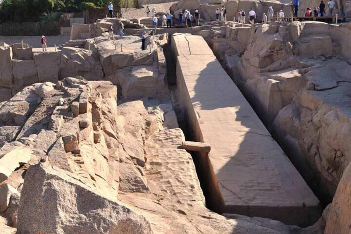 μια ομάδα ανθρώπων που περπατούν γύρω από μια μεγάλη πέτρινη κατασκευή