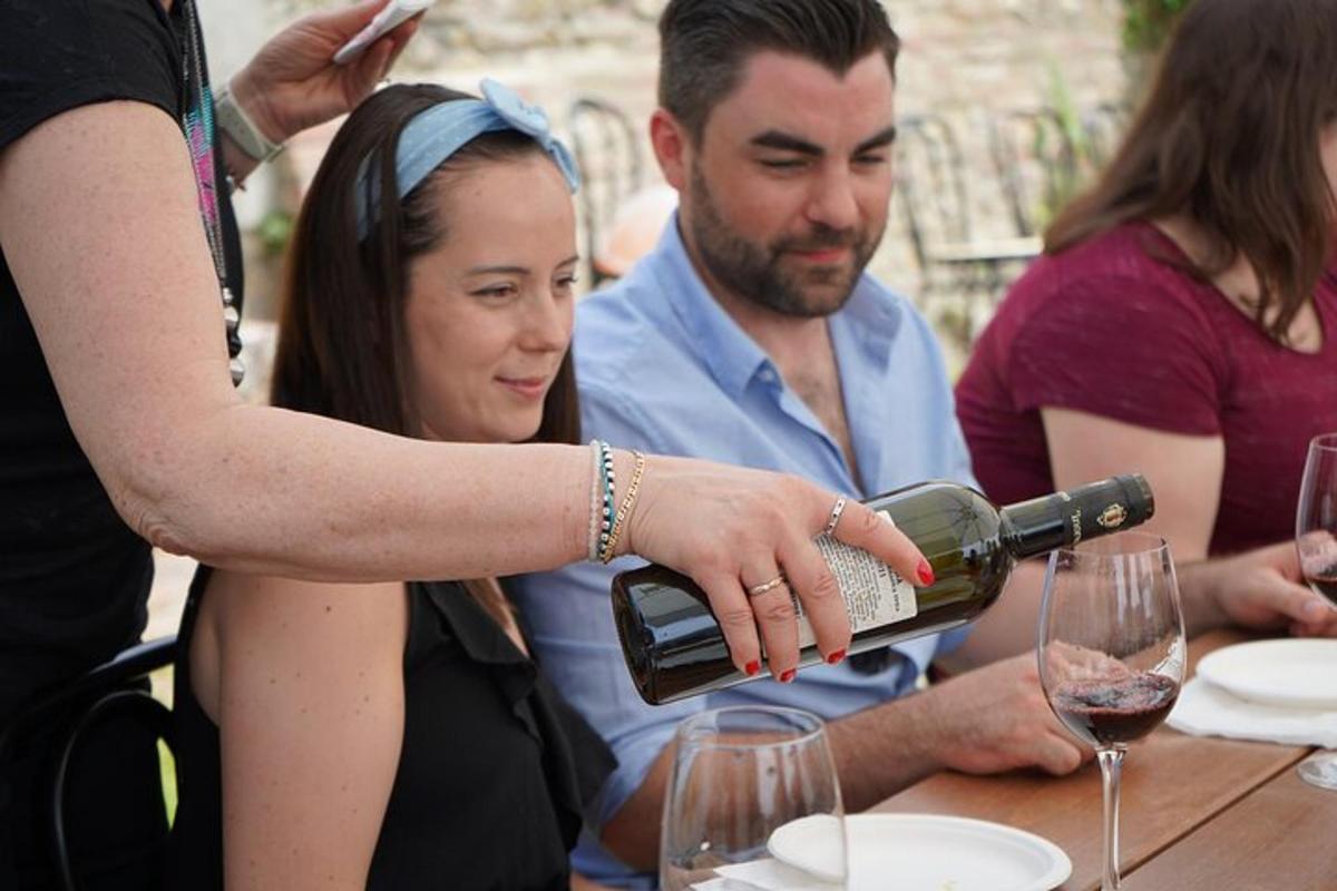 μια γυναίκα που σερβίρει ένα ποτήρι κρασί σε ένα τραπέζι