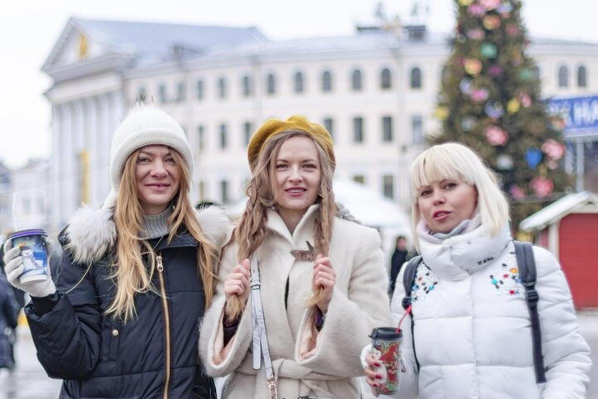 Két nő sétál az utcán egy karácsonyfa előtt