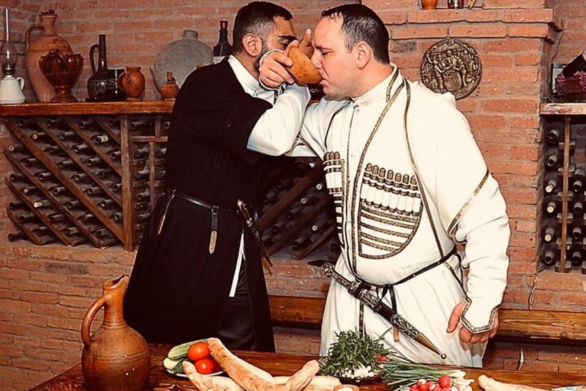 dois homens estão em uma cozinha comendo comida