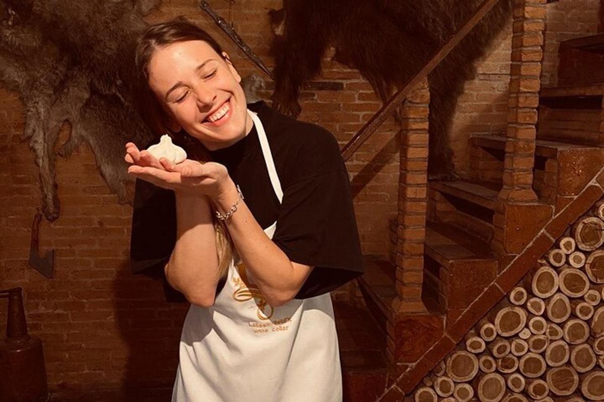 uma mulher sorri enquanto segura um pedaço de comida