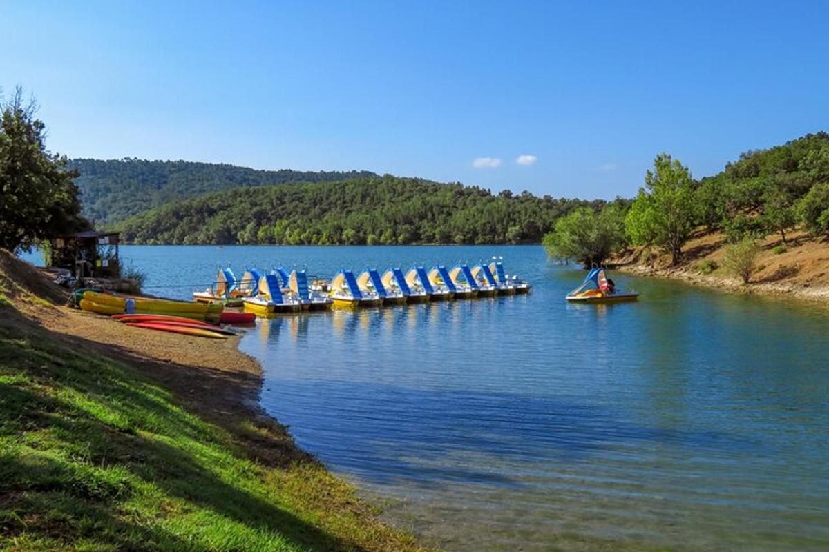 un grup de bărci pe un lac cu oameni pe ele