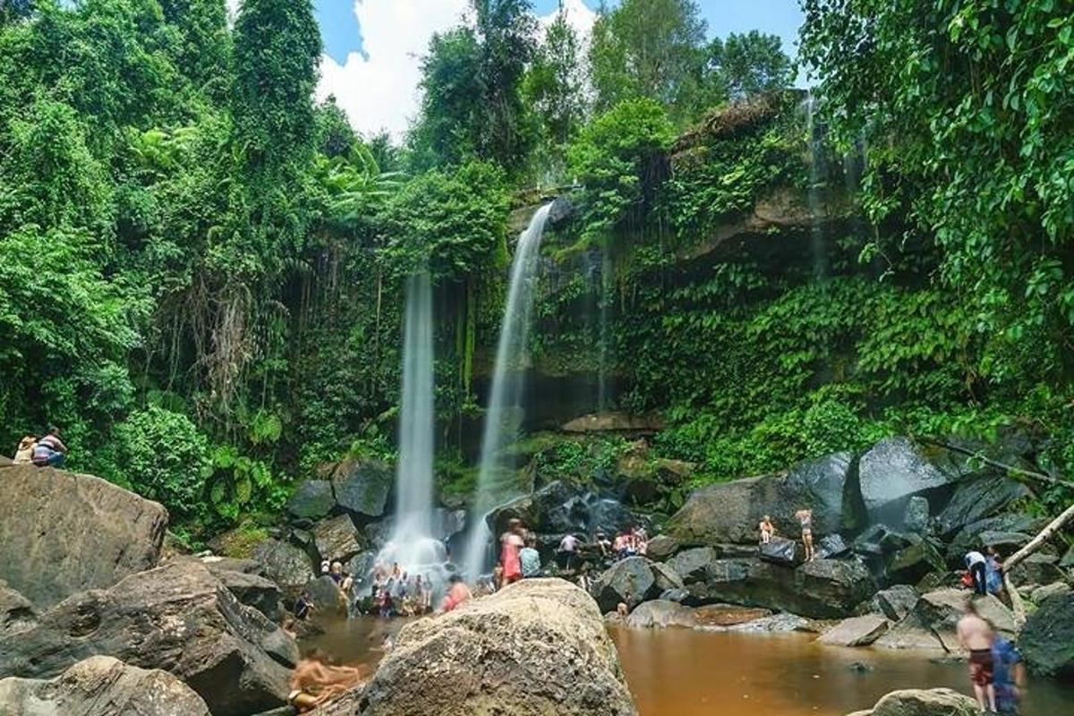 eine Gruppe von Menschen in einem Fluss mit einem Wasserfall