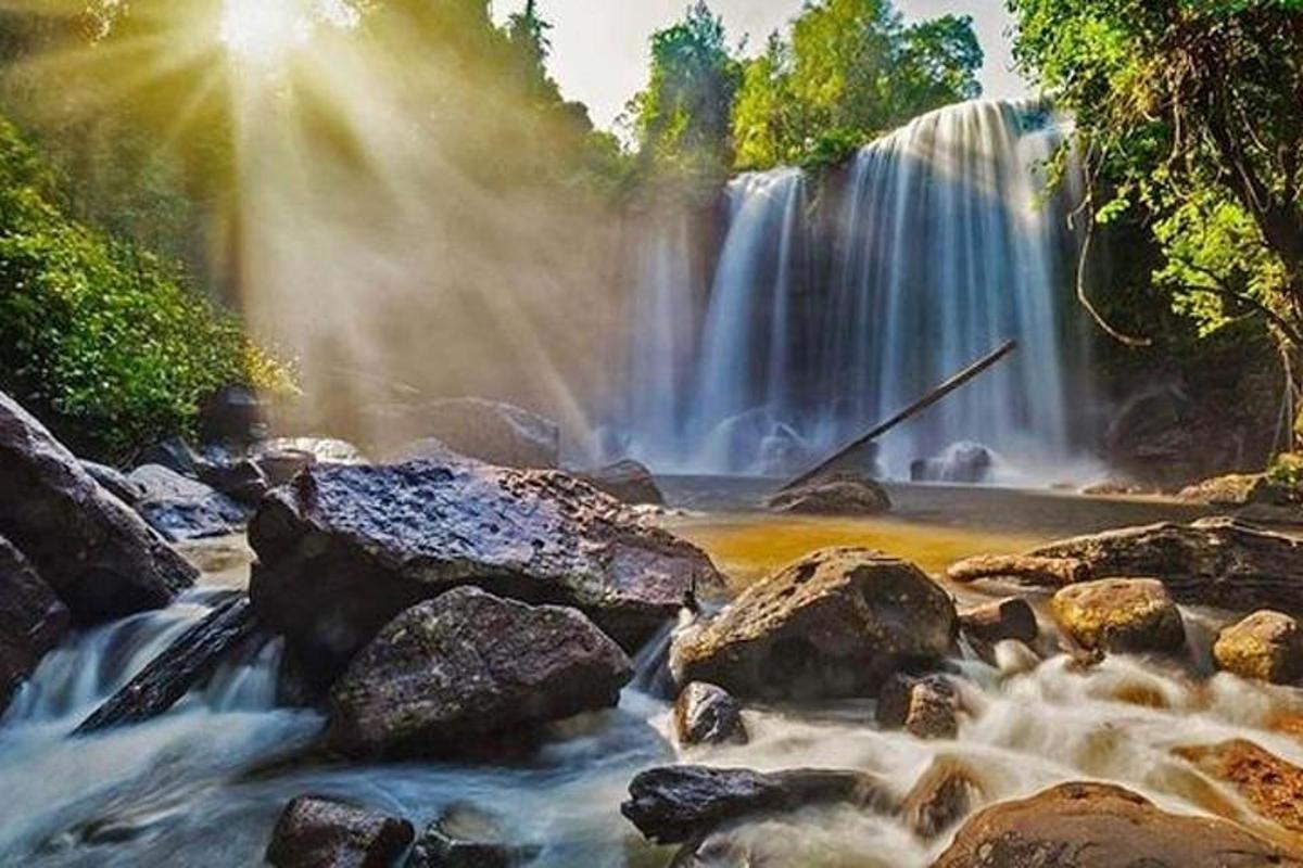 una cascata e rocce in un fiume con alberi