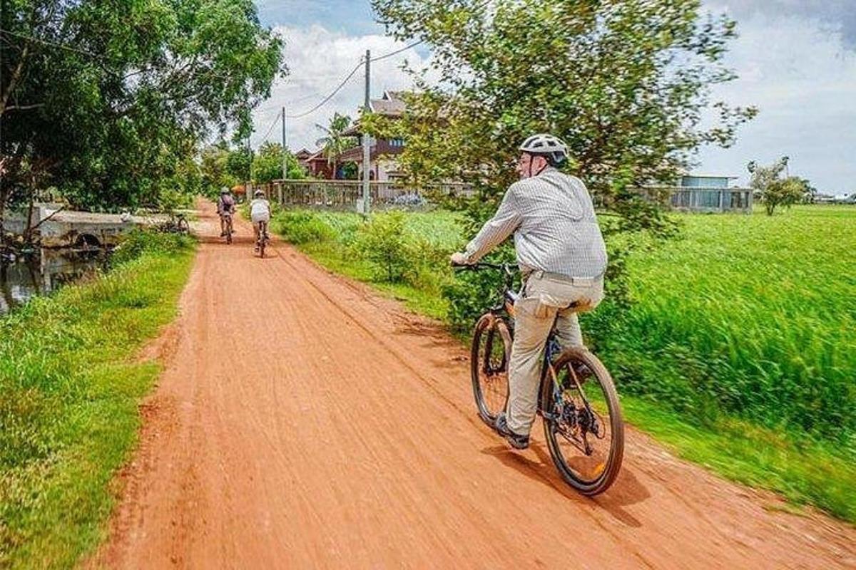 ein Mann, der mit dem Fahrrad einen Feldweg entlang fährt