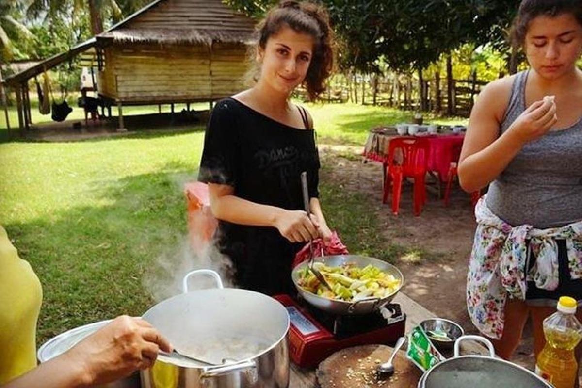 en kvinne som lager mat i en panne på en grill