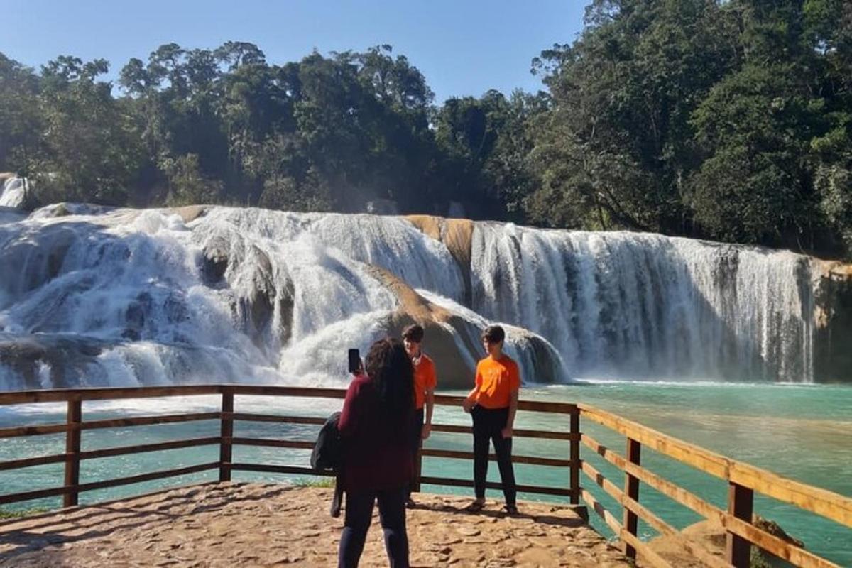 a group of people standing in front of a waterfall