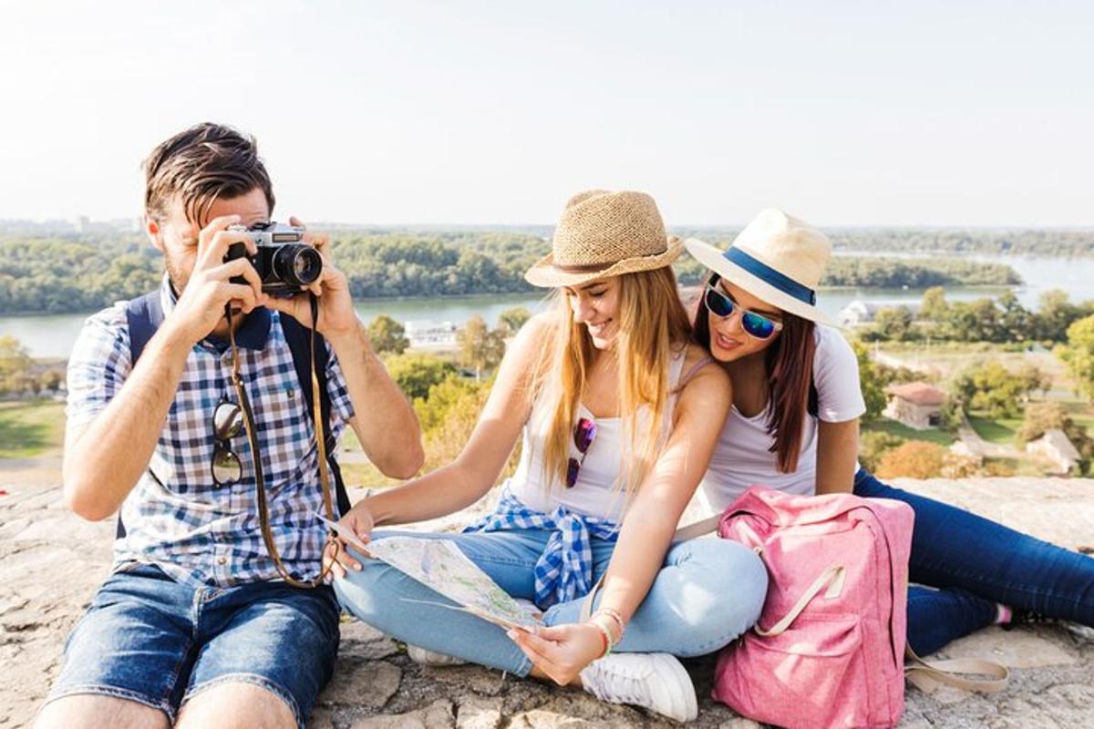a man and two women sitting on a rock with a camera