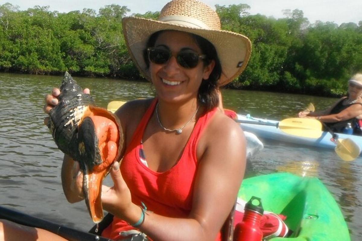 a woman in a kayak holding a large fish