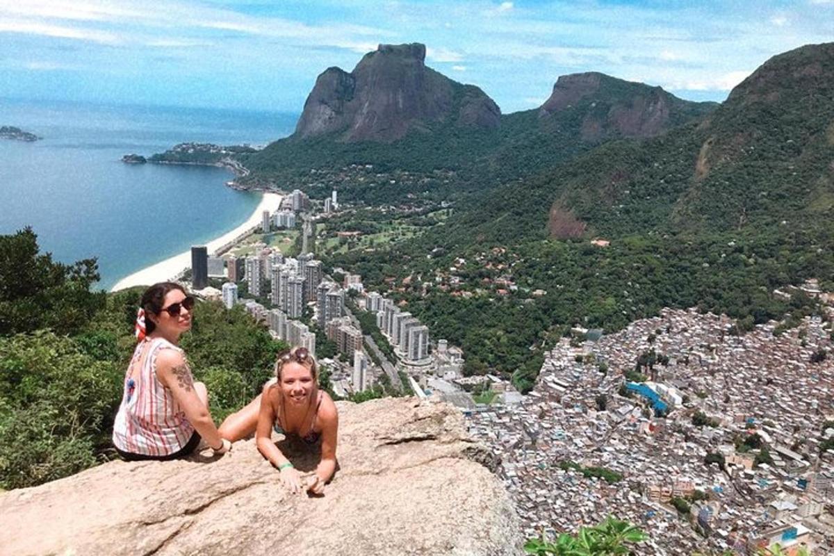 duas pessoas sentadas no topo de uma montanha
