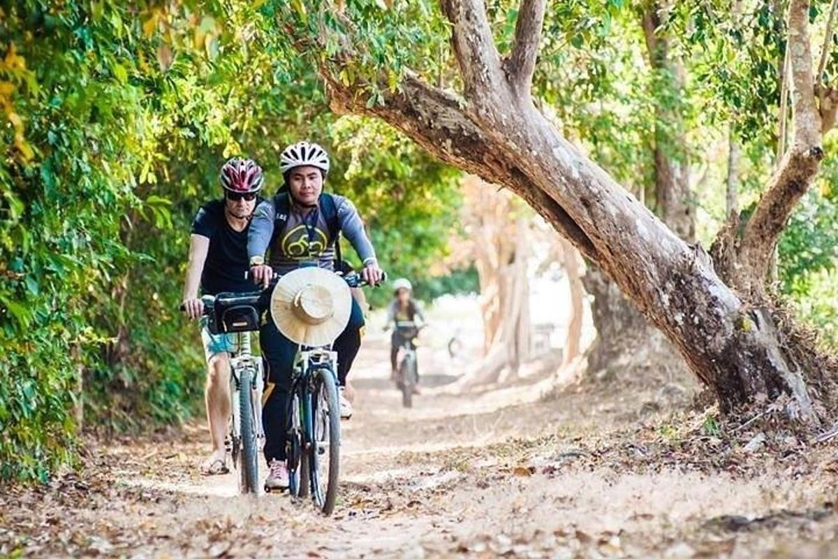 Un hombre y una mujer andan en bicicleta por un camino de tierra