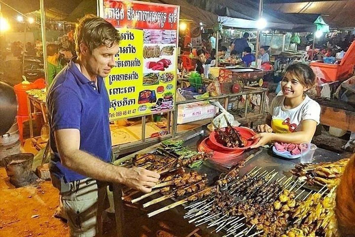 muž a žena připravují jídlo na trhu