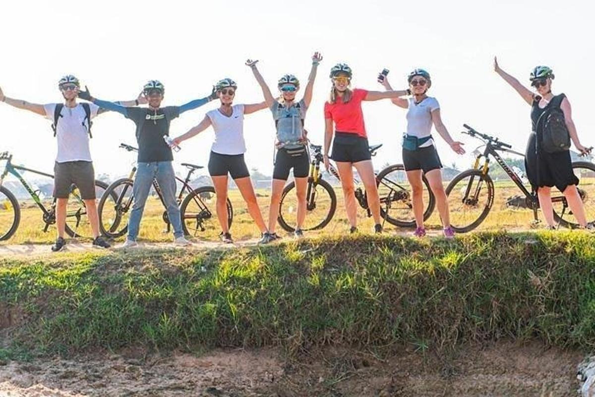 un grup de persones dretes en un turó amb les seves bicicletes