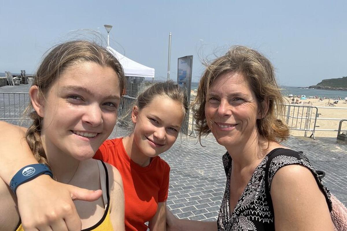 dues noies i una dona posant per a una foto a la platja