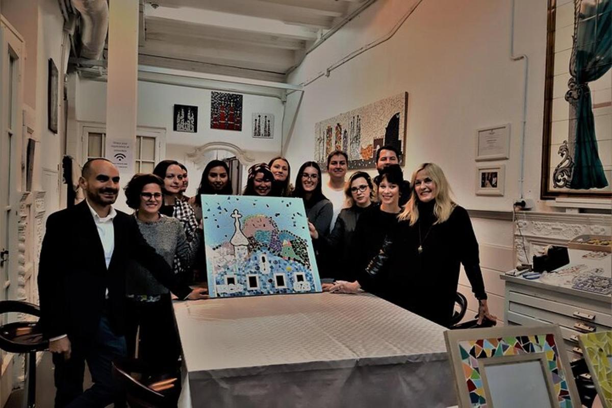 skupina lidí stojících kolem stolu s obrazem