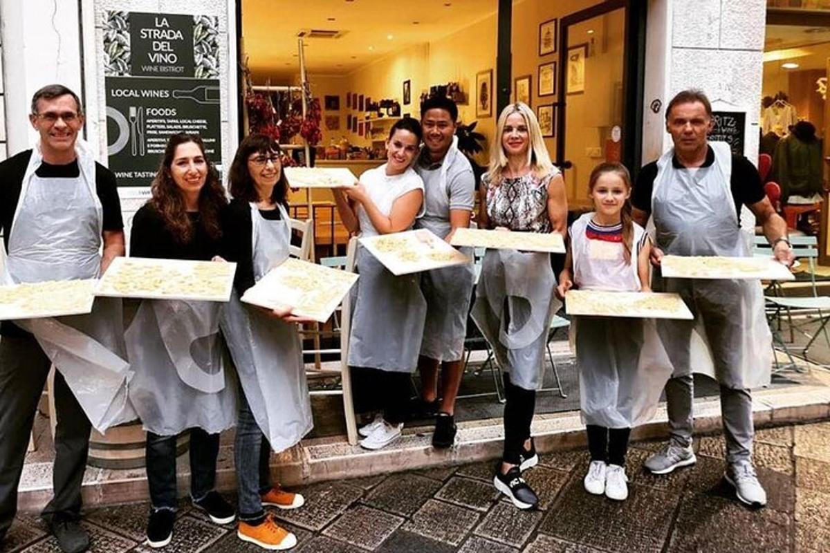 een groep mensen die pizza's vasthouden voor een winkel
