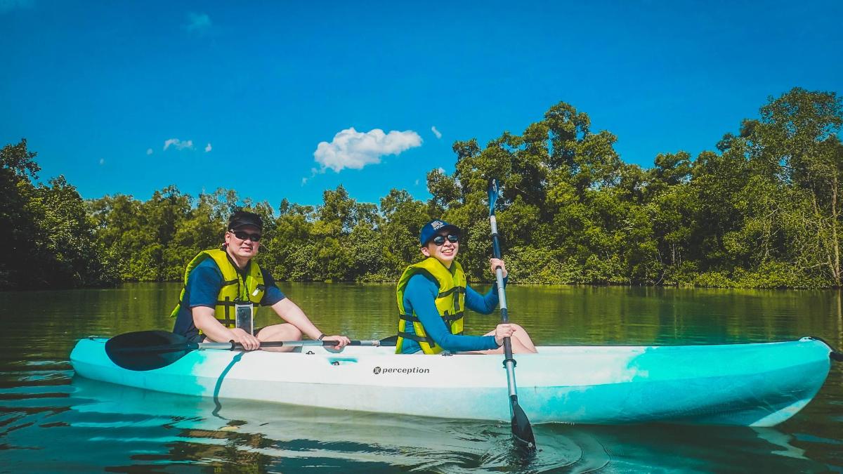 two men in a blue kayak on the water