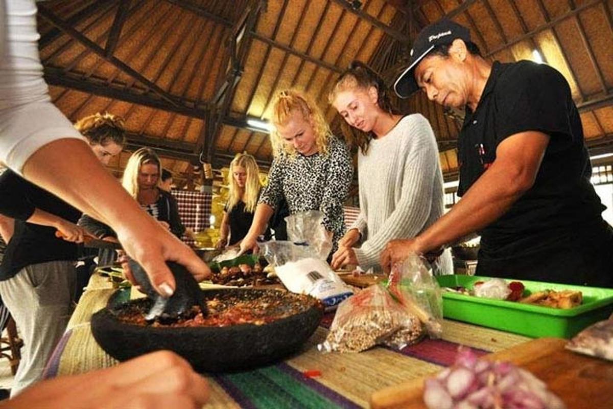 egy csoport ember áll egy asztal körül, ételt készít