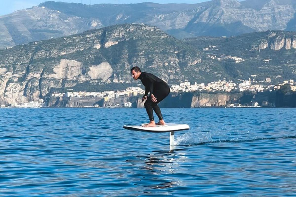 Ένας άντρας στέκεται σε μια σανίδα του σερφ στο νερό