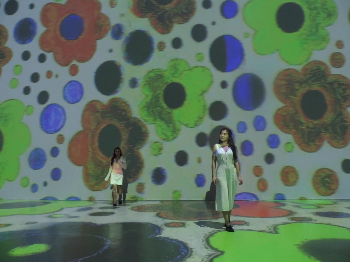 two models on a stage in front of a floral wall