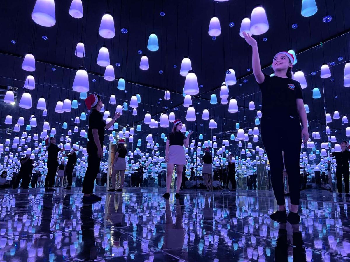 a group of people standing in a room with paper hearts