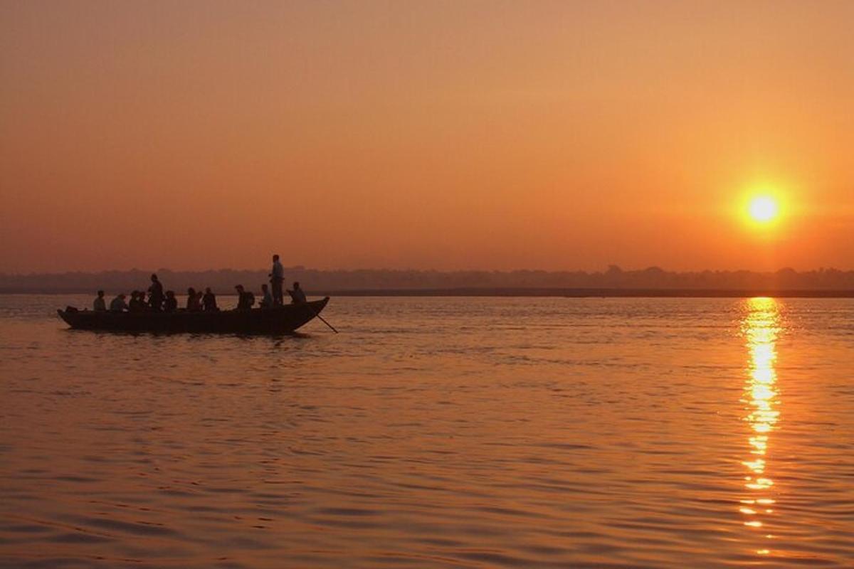 um grupo de pessoas em um barco na água ao pôr do sol