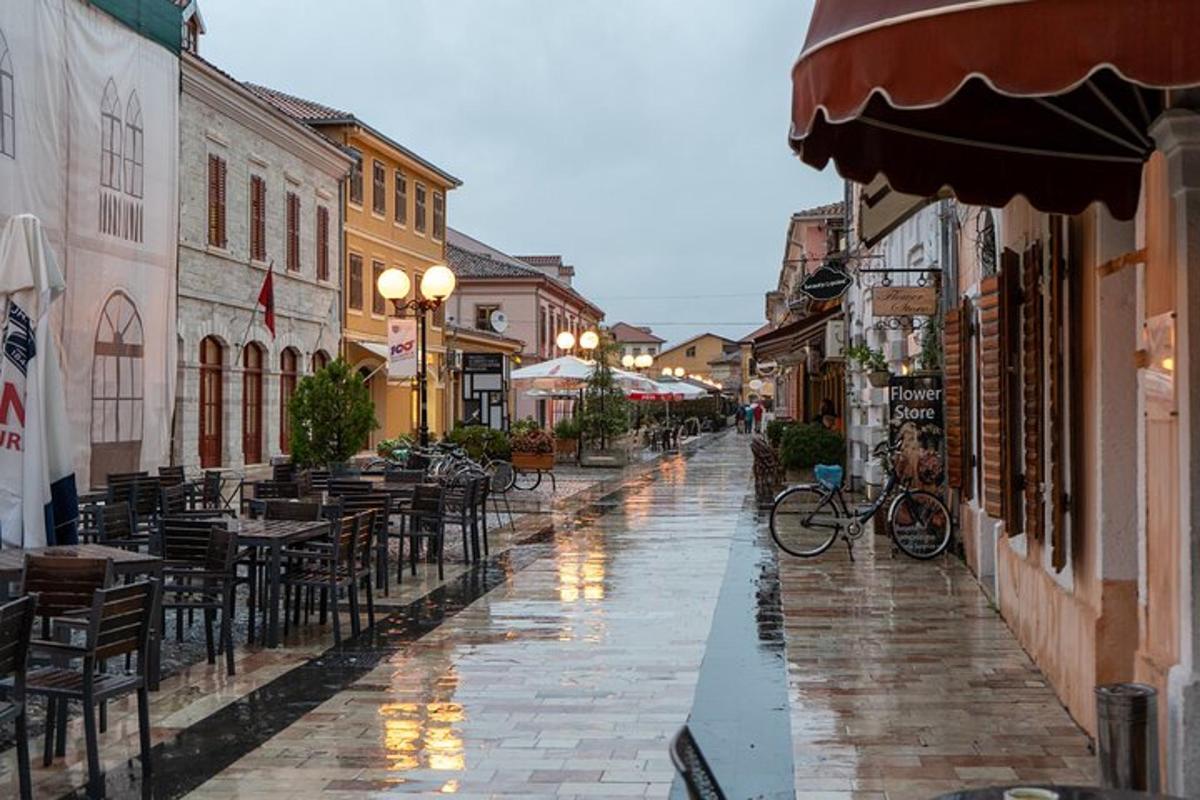 un carrer buit amb taules i cadires en un dia plujós