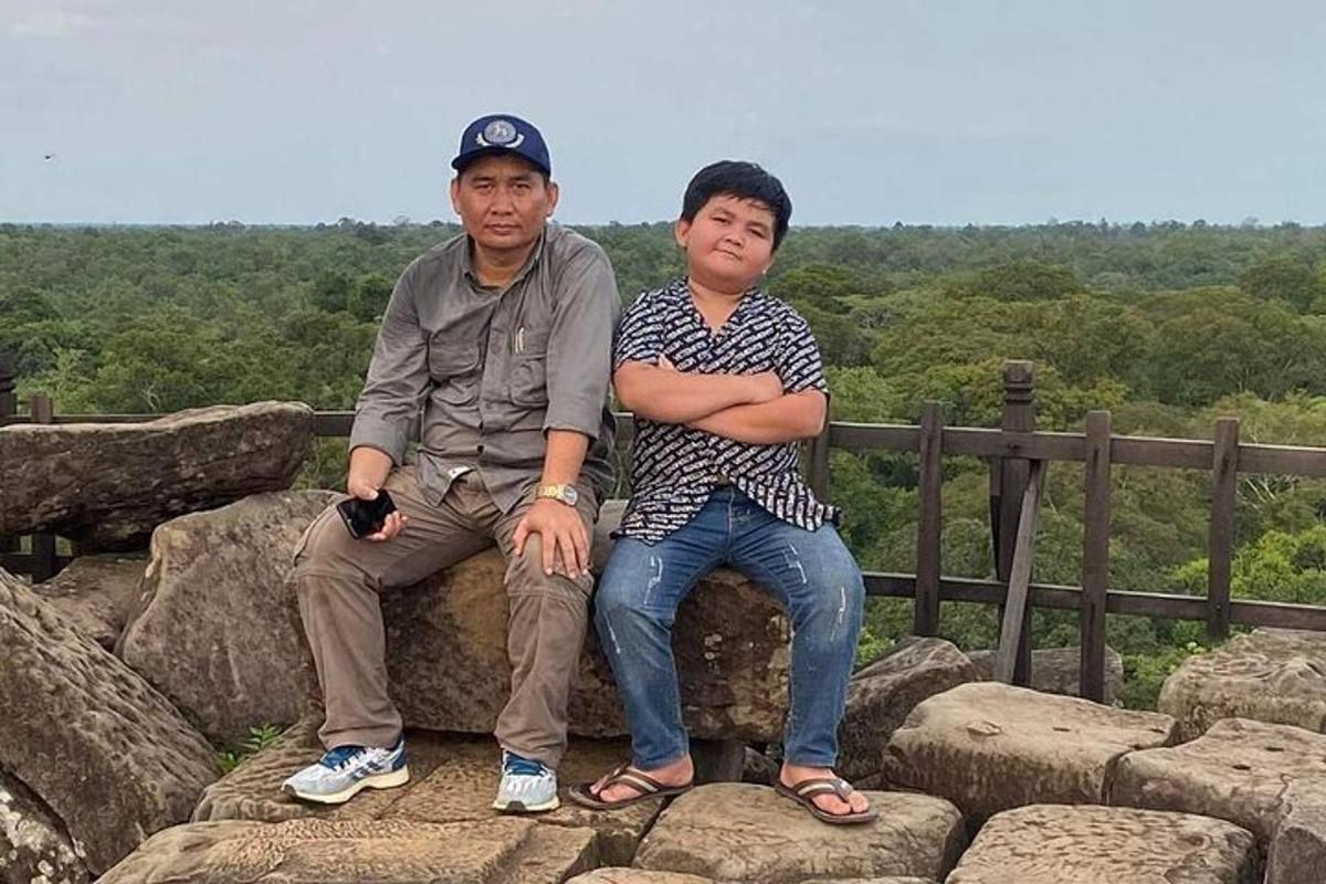 腕を組んで岩の上に座っている二人の男性