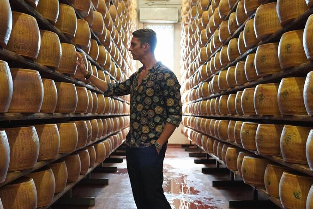 a man standing in front of a large stack of wine barrels