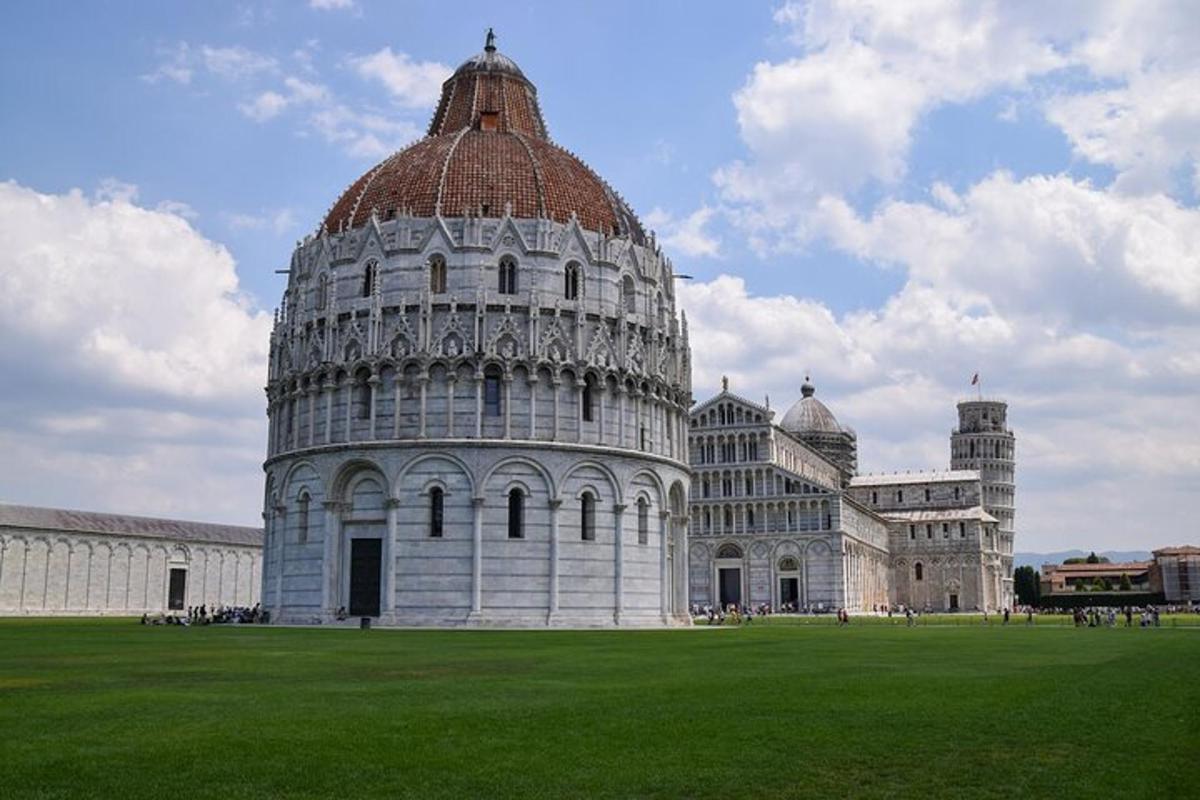 un grande edificio con una torre pendente su un campo verde