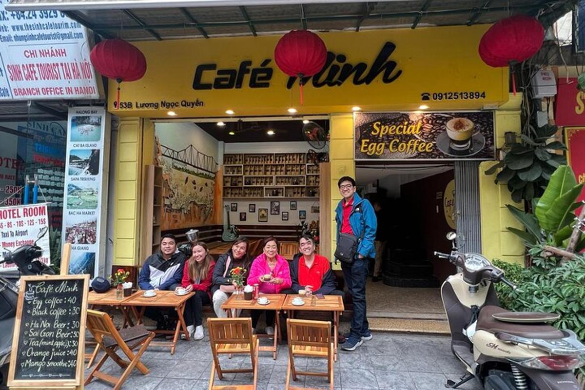 a group of people sitting at tables in front of a restaurant