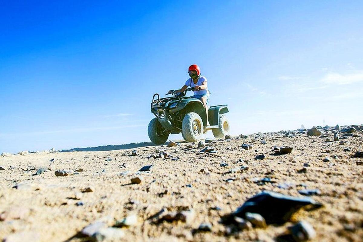 eine Person, die auf einem felsigen Feld ein Quad fährt