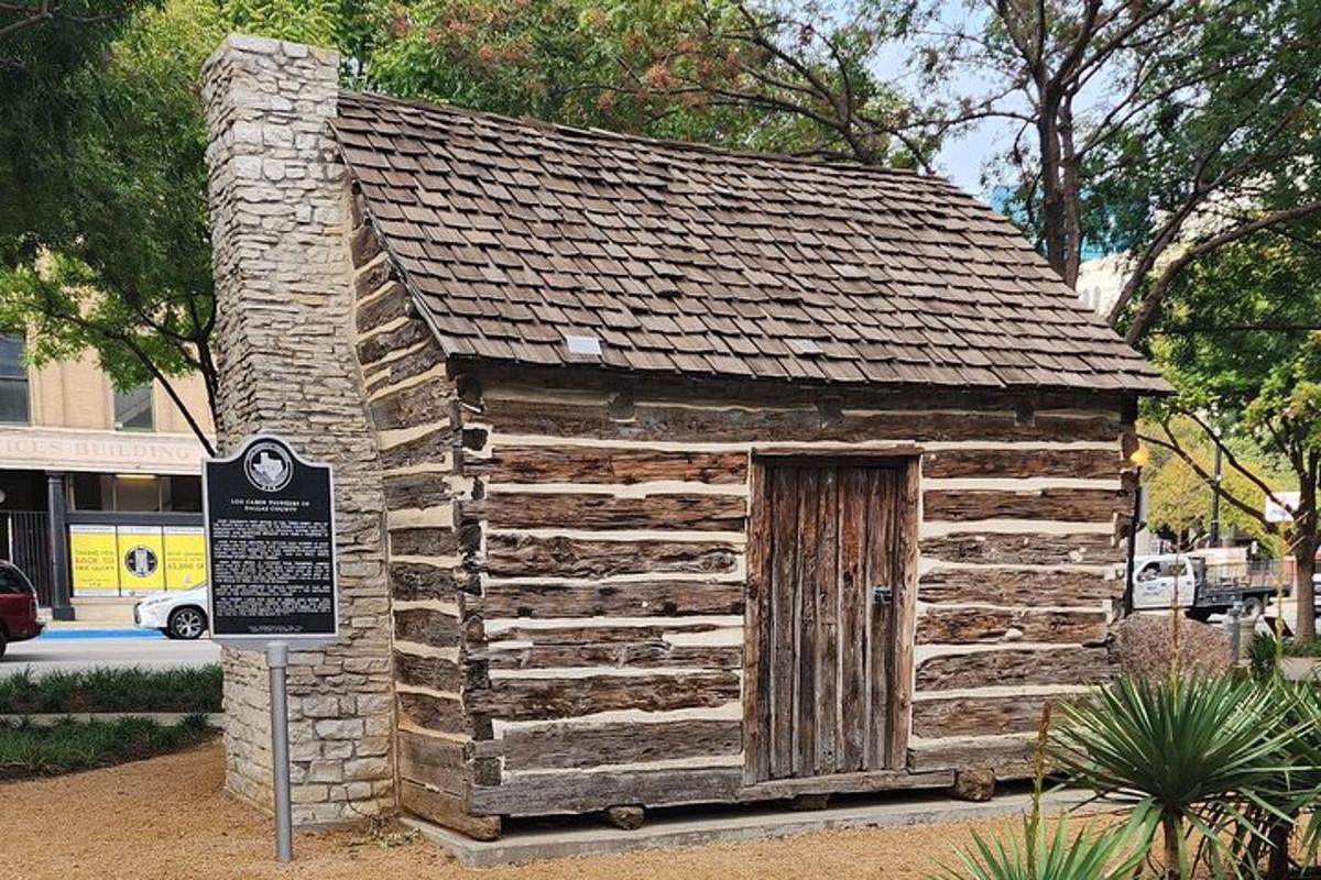 a small log cabin with a sign in front of it