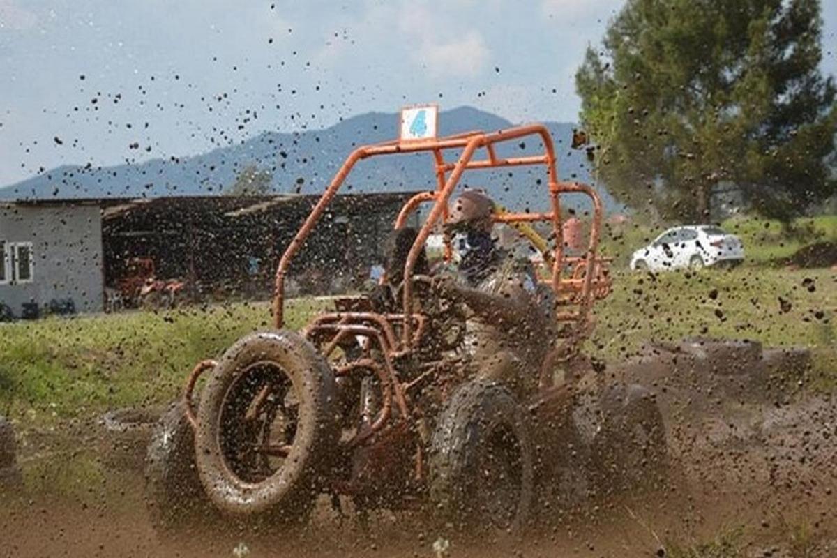 un uomo che guida un trattore nel fango