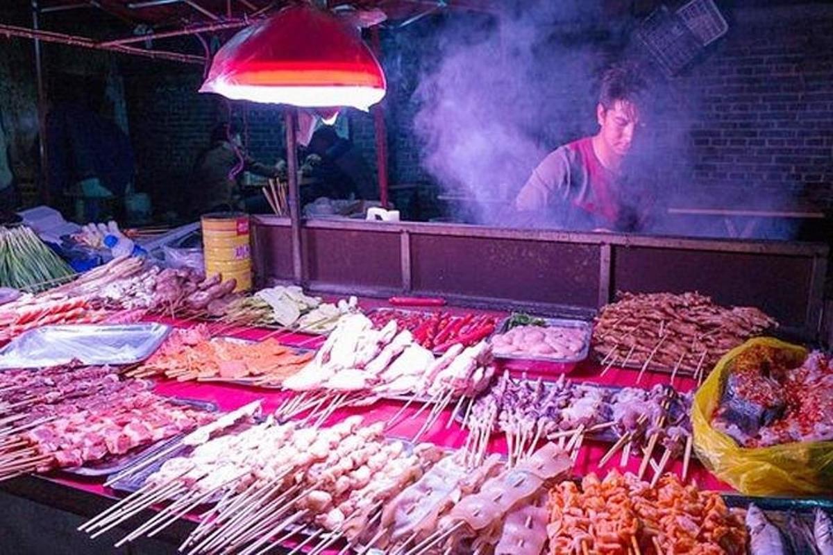 isang lalaking nakatayo sa isang palengke na may dala-dalang mga pagkain